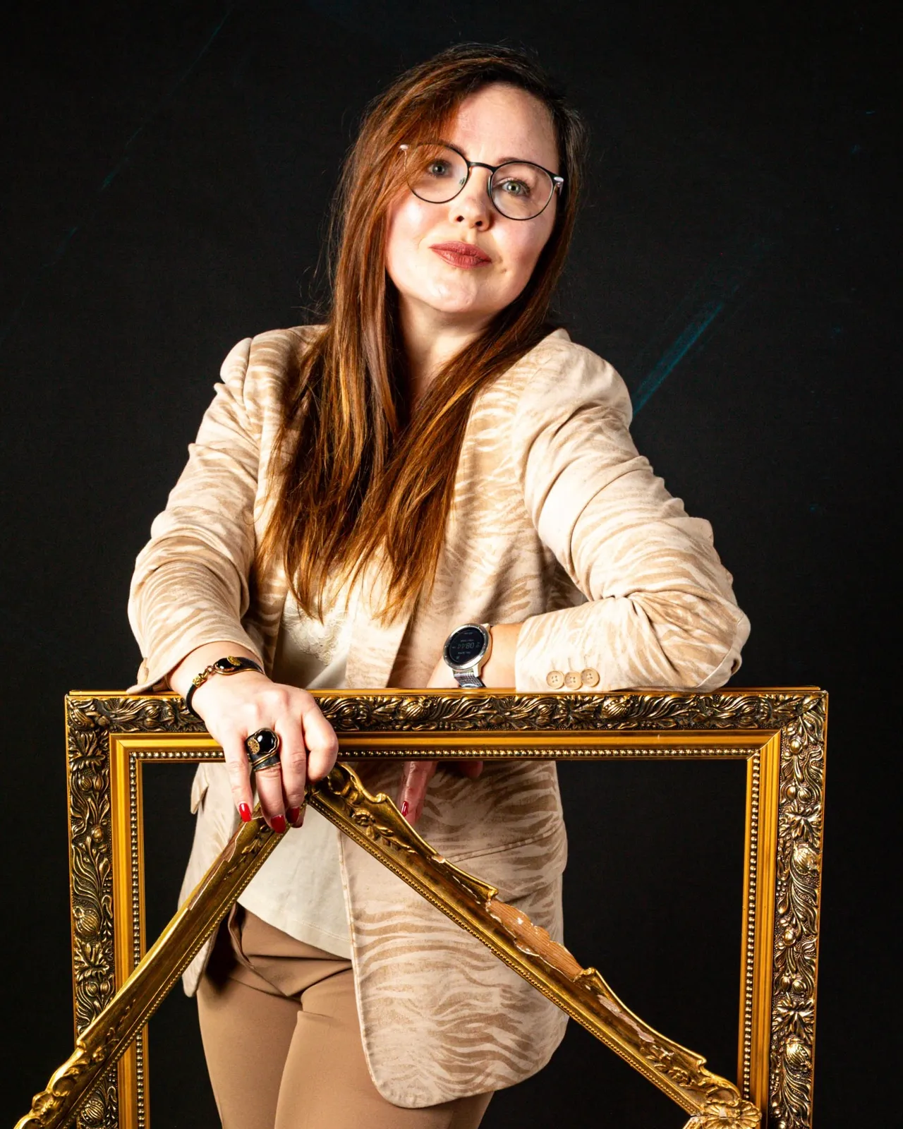 Natalia Slovesnova holding two golden picture frames.