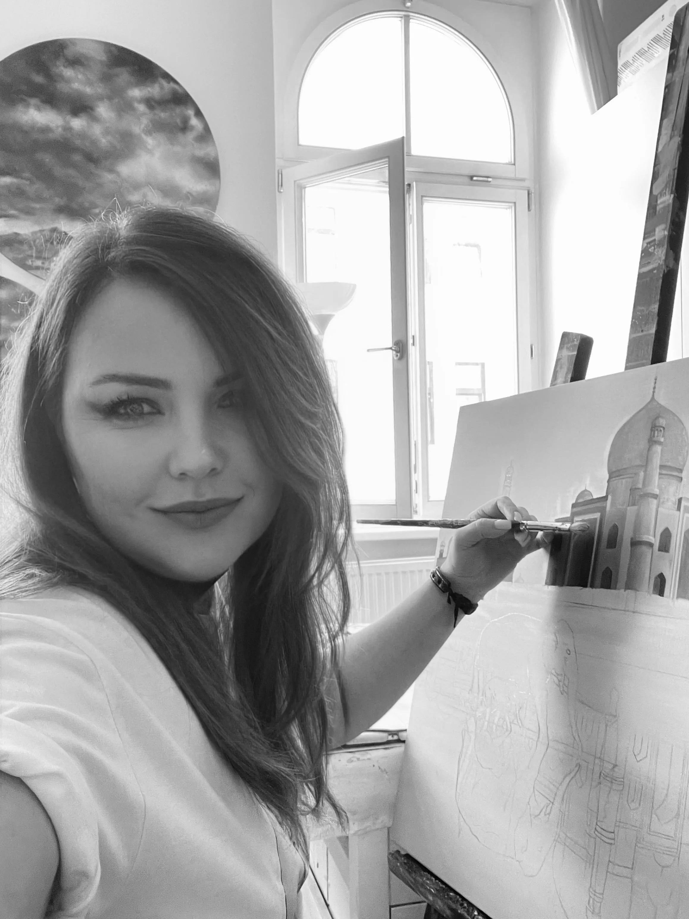 Natalia Slovesnova at her easel in a light-filled studio.